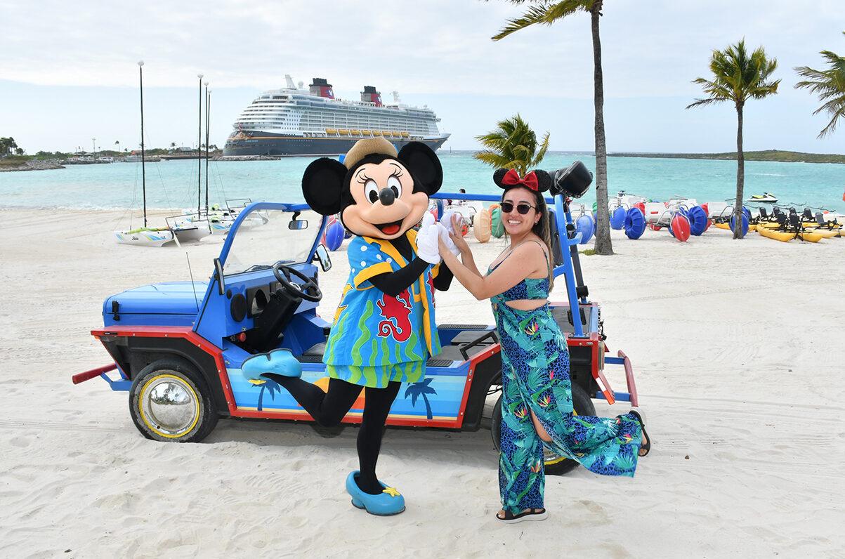 Mickey Mouse and woman enjoying tropical beach with cruise ship and palm trees.