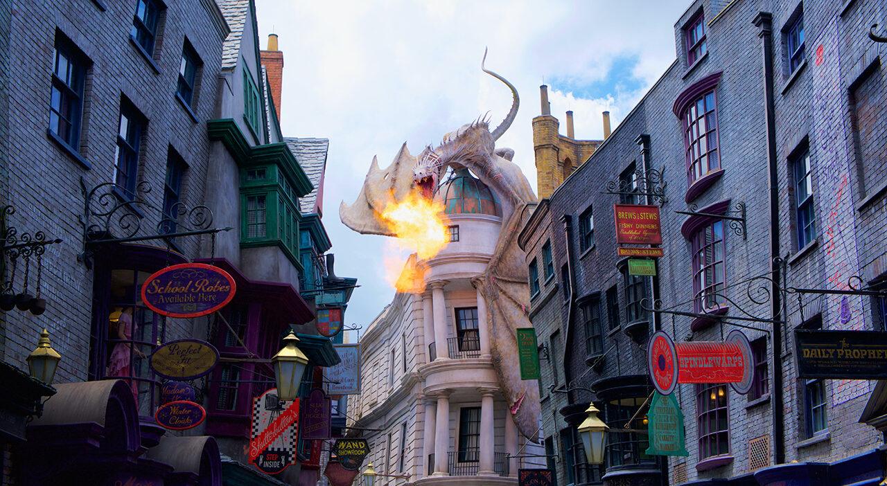 Fire-breathing dragon above colorful magical marketplace with cobblestone street and enchanted wizard shops.