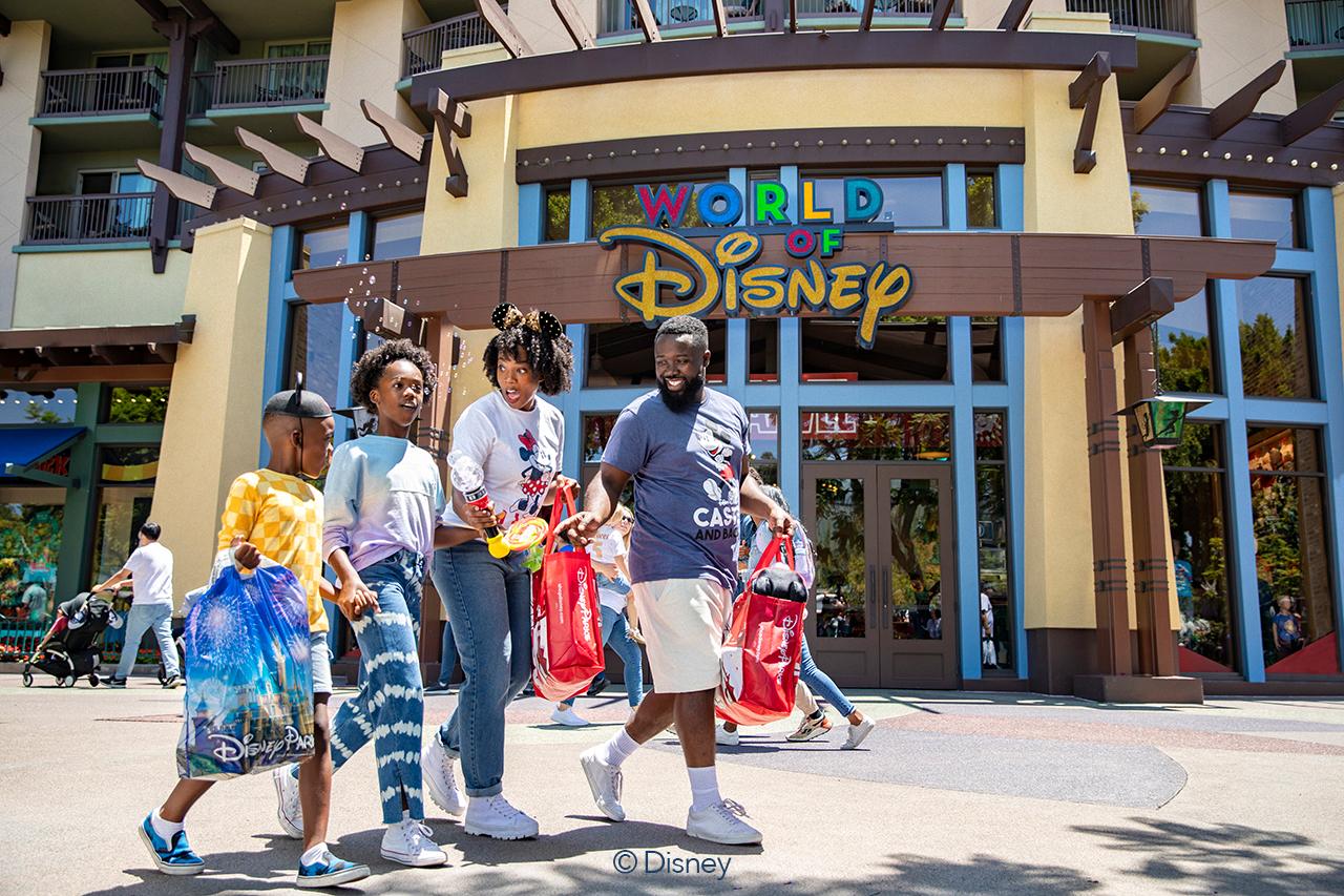 Family enjoying a sunny day outside the World of Disney store entrance.