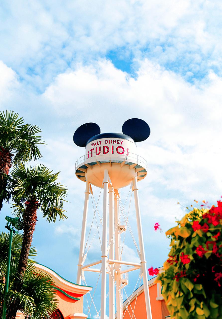 Disney water tower with Mickey ears at Walt Disney Studios surrounded by palm trees.