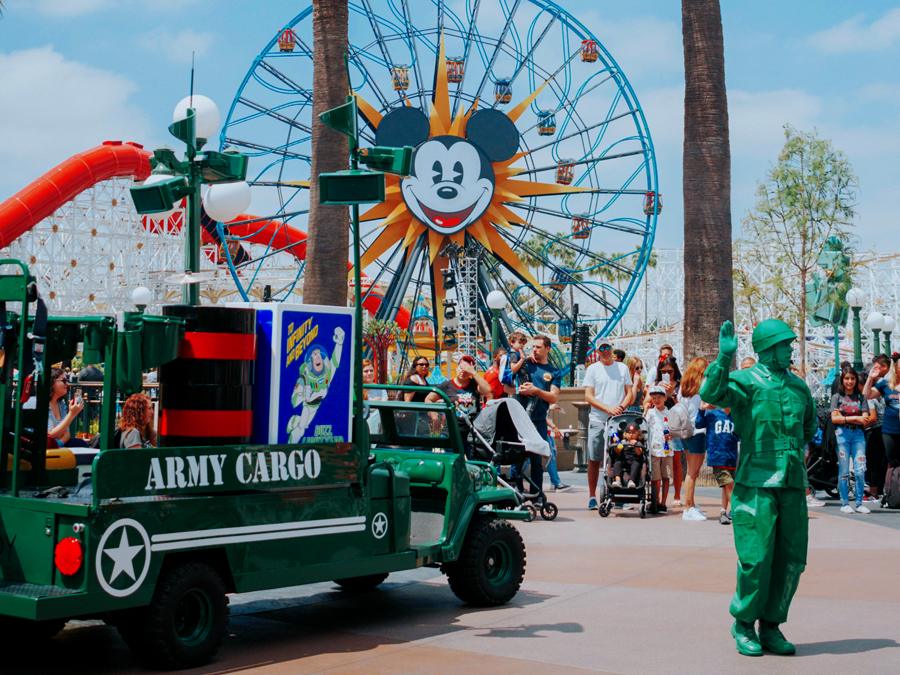 Kids celebrating with Disneyland $50 tickets at Disney California Adventure—Toy Story Green Army Men jeep parade with Mickey’s Fun Wheel in back