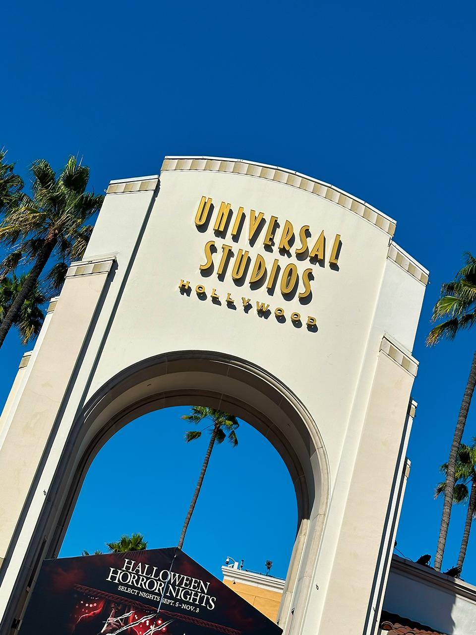 Universal Studios Hollywood entrance with palm trees and Halloween Horror Nights banner