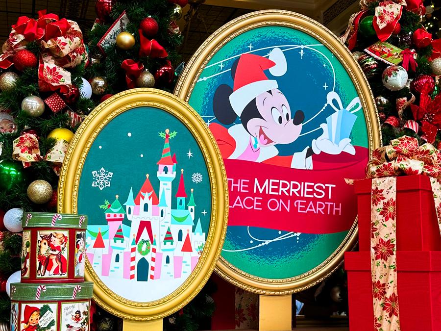 Mickey Mouse Christmas decorations at Disney World with festive signs, ornaments, and holiday tree.